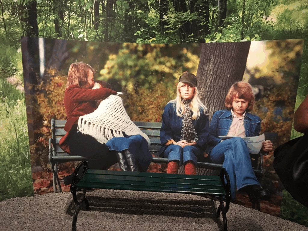 ABBAのメンバー4人が公園のベンチに座っている名シーンを再現した写真パネルとベンチの展示