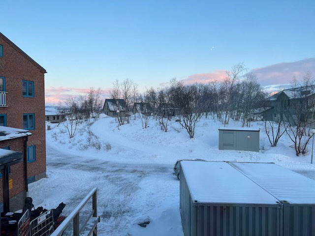 夕方のアビスコ。淡い夕陽に染まる雪原と建物のシルエット