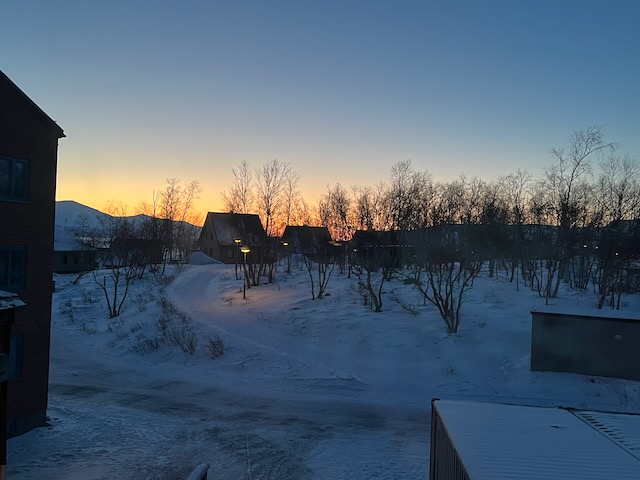 夜明け前のアビスコ。建物越しに広がる薄明の雪景色