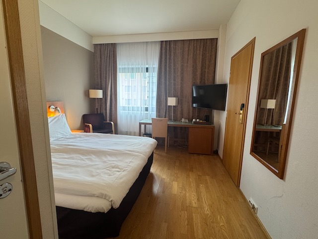 ホリデイ イン ヘルシンキ-ヴァンター エアポートのスタンダードクイーンルーム全景。窓際とデスクの配置。