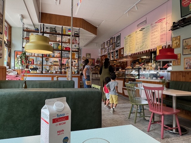 Älskade Traditionerのカウンターとパステルカラーの椅子が並ぶ店内