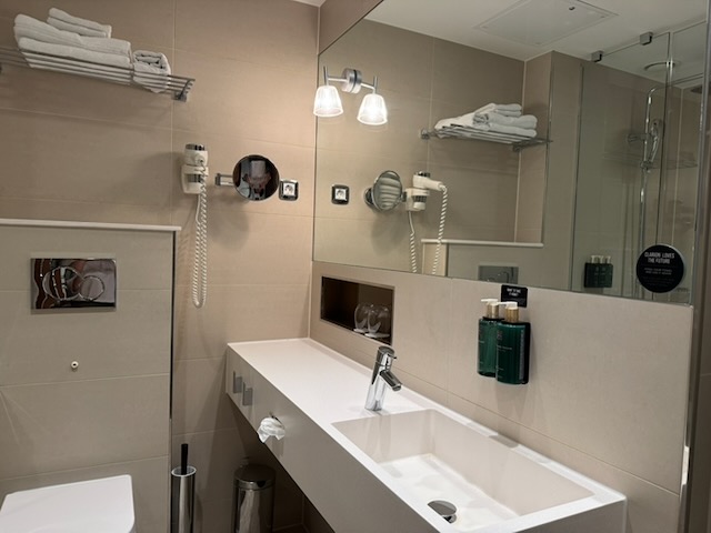 Clarion Hotel Arlanda Airport Terminalの広い洗面台、大型鏡、壁付けアメニティ