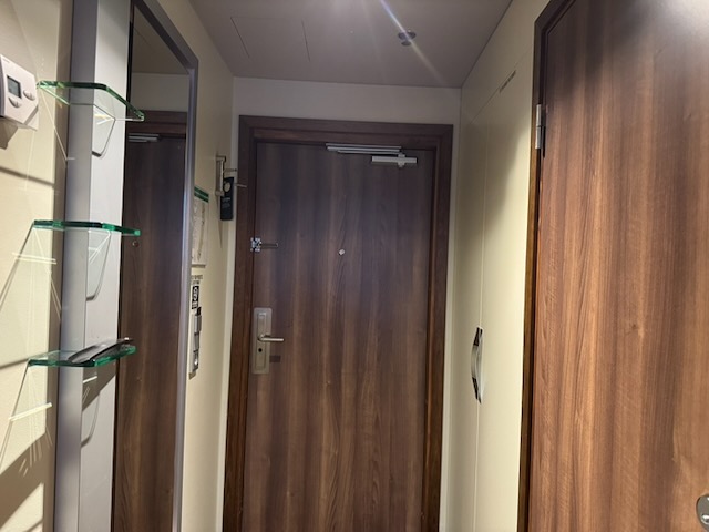 Clarion Hotel Arlanda Airport Terminalの客室入口にある木目調のドアと鏡付きの通路